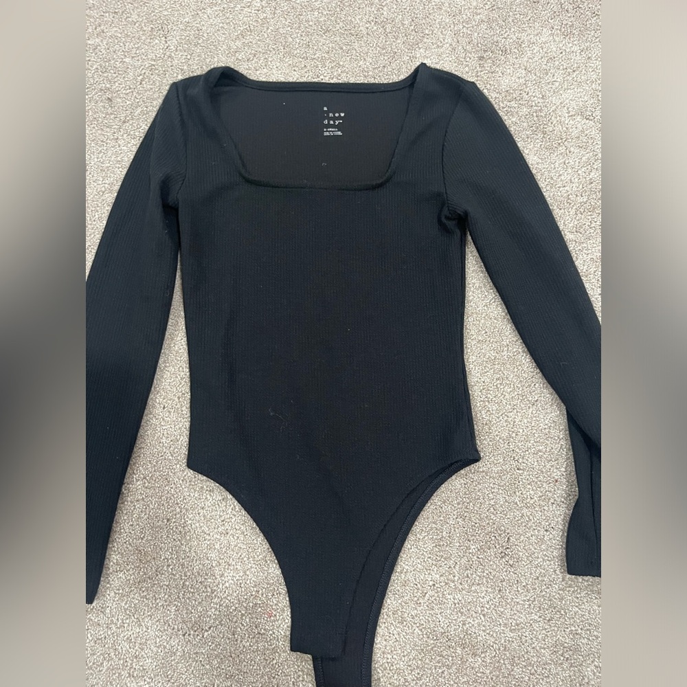long sleeve black body suit with buttons at the bottom of it. Never worn